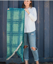 Load image into Gallery viewer, Picture shows our range of Fun Cozy Winter Scarves - in 7 colour ways. This one the Blue Green Option. This acrylic blend wonder is super soft, non-bulky, and an extra layer of warmth for the season. In a stylish check pattern, it&#39;s the perfect partner for your winter ensemble. The rectangle shape with frayed angled edges adds that finishing touch.
