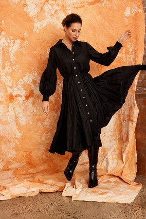 Image shows the Bachi dress from Kamare, a classic shirt dress in 100% crushed silk which can be worn to any occasion. Creativity designed with gorgeous features available in Black (as shown) or Khaki. Size range 8, 10, 12, 14