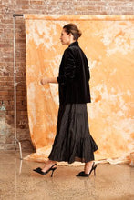 Load image into Gallery viewer, Image shows a woman wearing the CRUSHED SILK MAXI SKIRT-from Kamare brand in Black Creativity designed with gorgeous features you will be sure to turn heads when you head out in this masterpiece. Its midi length, has a full skirt is lined and made of 100% crushed silk
